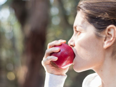 Mini Dental Implants Woman Eating Apple with mini implants